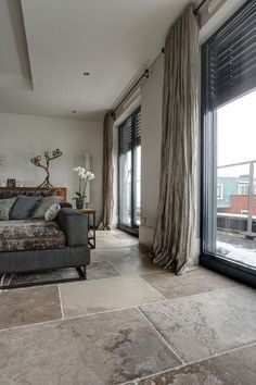 a living room filled with furniture and large windows