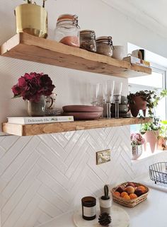 two shelves filled with dishes and cups on top of a counter