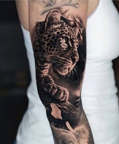 a woman's arm with a black and white tattoo on it, featuring an image of a leopard