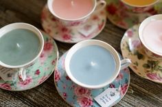 four tea cups and saucers with labels on them sitting on a table next to each other