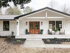 a white house with two chairs on the front porch