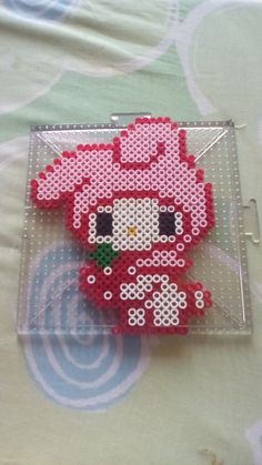 a plastic tray with a red hello kitty bead doll on it's side