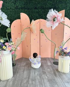 three vases with flowers are sitting on a wooden table in front of a wall