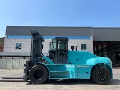 a blue forklift parked in front of a building