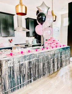 balloons and streamers are hanging from the ceiling in this party - like kitchen area