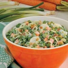 a bowl filled with peas and carrots on top of a table