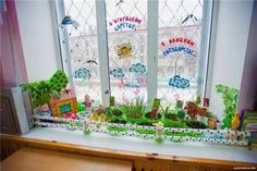 a window sill filled with lots of plants next to a refrigerator freezer covered in magnets