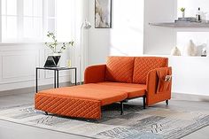 an orange couch sitting on top of a rug in a living room