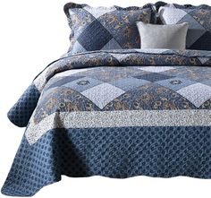 a blue and white quilted bed with pillows