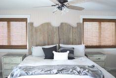 a bedroom with a bed, two nightstands and a ceiling fan