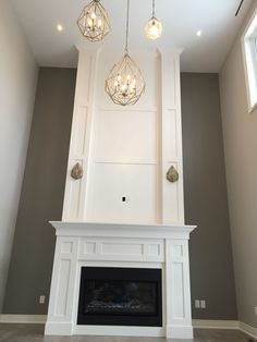 a living room with a fireplace and chandelier hanging from the ceiling above it