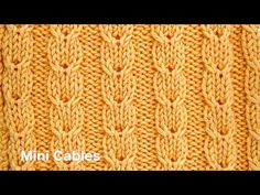 an orange knitted blanket with the words mini cables written on it