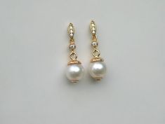 "Lustrous white freshwater pearls dangling from tiny cz connectors and paired with cz pavé petite marquise 14k gold plated studs. Simply classic pearl earrings for multiple occasions. - Pearls are approx 7.5mm. - Earrings measure just under 1\" ( 2.4cm ) overall. - Metal components: 14k gold filled, 14k gold plated studs ( gold over sterling silver ). My shop main page https://www.etsy.com/shop/LeeWen" White Pearl Earrings For Wedding With Round Beads, White Pearl Earrings With Round Beads For Wedding, White Round Beads Pearl Earrings For Wedding, White Round Pearl Earrings For Wedding, Classic Pearl Earrings, Classic Vintage Style, Ivory Earrings, Studs Gold, Simple Pearl