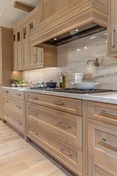 a kitchen with wooden cabinets and white marble counter tops, along with wood flooring