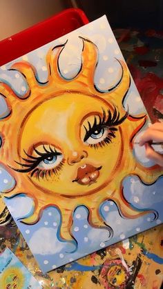 a person is painting a sun on a canvas