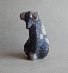 a black and white ceramic animal sitting on top of a gray surface with polka dots