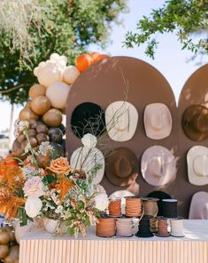 a table topped with lots of vases filled with flowers and plates on top of it