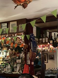 the bar is decorated with green, orange and white pennants hanging from the ceiling