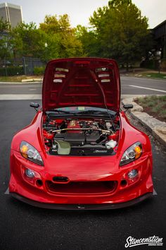 a red sports car with its hood open