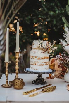 a table topped with a cake next to candles and other decorating items on top of it