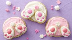 two decorated cookies sitting on top of a purple table