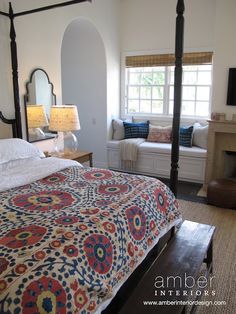 a bedroom with a bed, dressers and mirror in it's center area