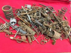 a pile of old metal items on a red cloth with scissors and wrenches in the background