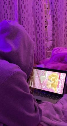 a person in a purple hoodie using a laptop computer