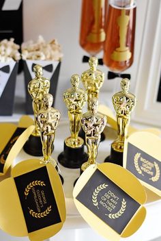 several awards are sitting on a table with popcorn in the background and other items around them