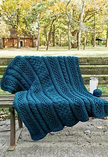 a blue blanket sitting on top of a wooden bench