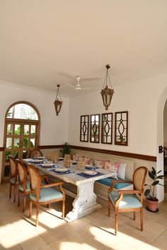 a dining room table set for four with blue and white place mats on the floor