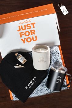 an orange box containing a coffee cup, mug and other items on a wooden table