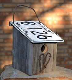 a bird house with scissors on top of it