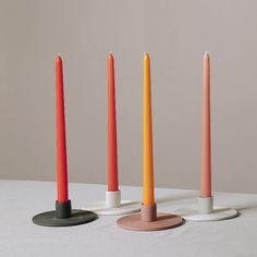 four candles are lined up in different colors