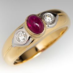 This lovely ring is centered with one (1) oval cabochon cut natural ruby set into a bezel. The shoulders are each accented with one (1), flush set, round brilliant cut diamond. The ring measures 6.7mm at the top, rises 6.8mm above the finger, tapering to 3.1mm wide and 0.8mm thick at the base of the shank. This ring is currently a size 8.5. Oval Cabochon Ruby Ring With Diamonds, Formal Ruby Ring With Diamond And Oval Cabochon Shape, Formal Oval Cabochon Ruby Ring With Diamond, Oval Cabochon Ruby And Diamond Ring, Classic Ruby Ring With Diamond And Polished Finish, Classic Cabochon Diamond Ring For Anniversary, Formal Oval Cabochon Ruby Ring With Bezel Setting, Classic Ruby Ring With Tension Setting, Classic Round Ruby Ring With Tension Setting