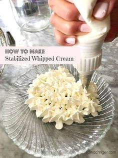 someone is adding cream to some food on a glass plate