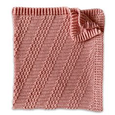 a pink knitted blanket with a bow