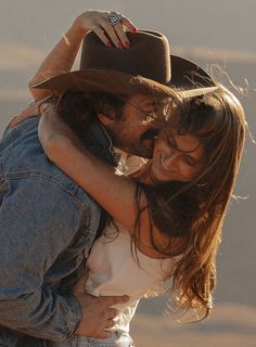 a man in a cowboy hat hugging a woman