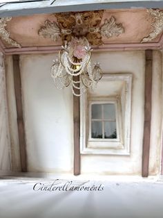 a chandelier hanging from the ceiling in a room with white walls and ceilings