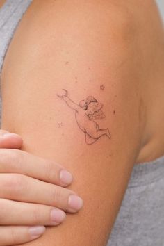 a woman's arm with a small tattoo design on the left side of her arm