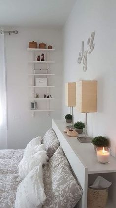 a bedroom with a bed, two lamps and a shelf on the wall above it