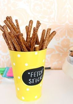 a cup full of churro sticks sitting on top of a table