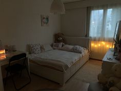 a bed room with a neatly made bed and a teddy bear