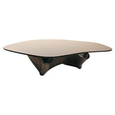 an oval glass table with black legs and a curved base, on a white background