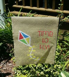 a towel hanging from a clothes line with a kite on it's side and the words time to fly printed on it