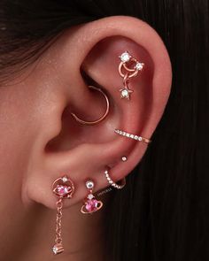 a woman wearing three different types of ear piercings