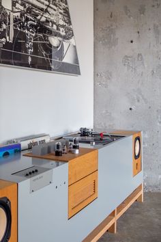 an old record player is sitting on top of a cabinet in a room with concrete walls