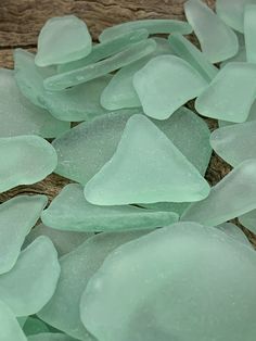 sea glass is laying on top of a piece of wood