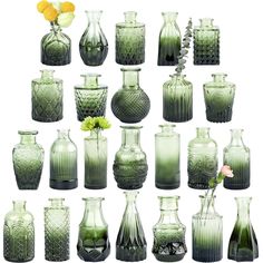 many green vases with flowers in them on a white background and one is empty