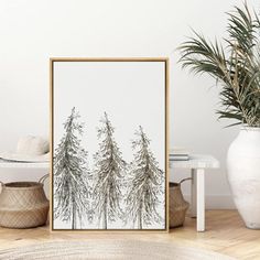 an art print on a wall next to a potted plant in a living room